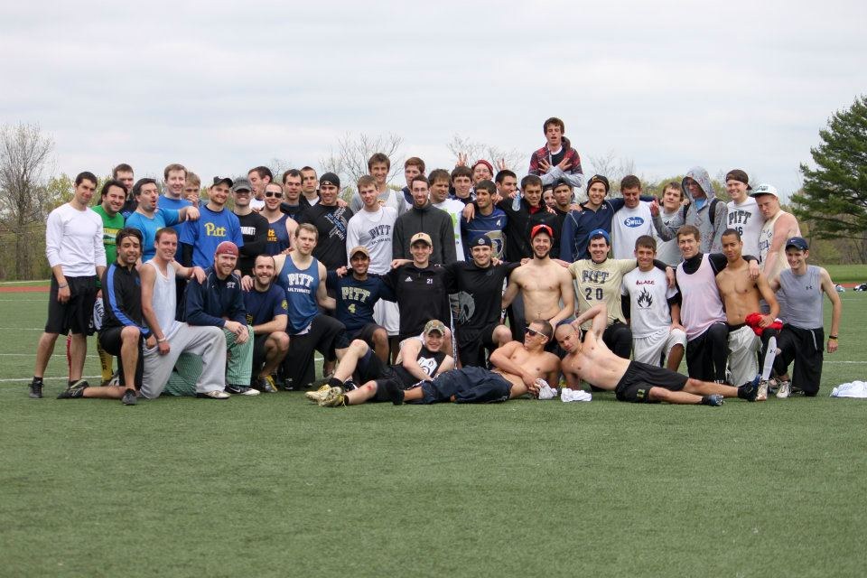 Alumni and current players spread out on the grass after the alumni game, 2012